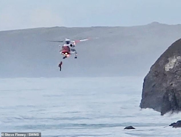Mobile phone footage shows how precarious the man's position was after being airlifted above the raging tides. It is believed that he fell on the rocks.