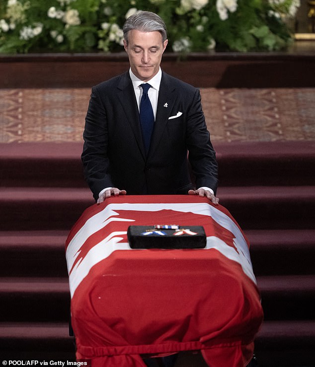 Ben Mulroney places his hands on his father's coffin after giving a reading during the state funeral of former Prime Minister Brian Mulroney at the Notre-Dame Basilica in Montreal.