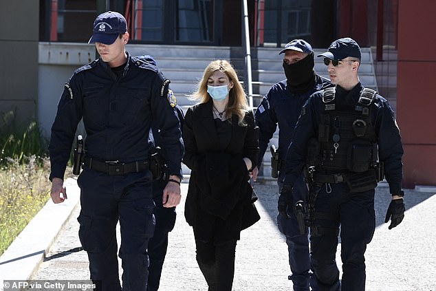 Police officers escort Roula Pispirigou (center), a 35-year-old woman on trial for killing her three daughters over three years, to court in Athens on March 29, 2024.