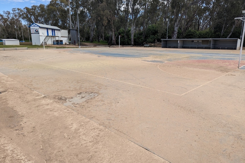 A netball court covered in dried mud.