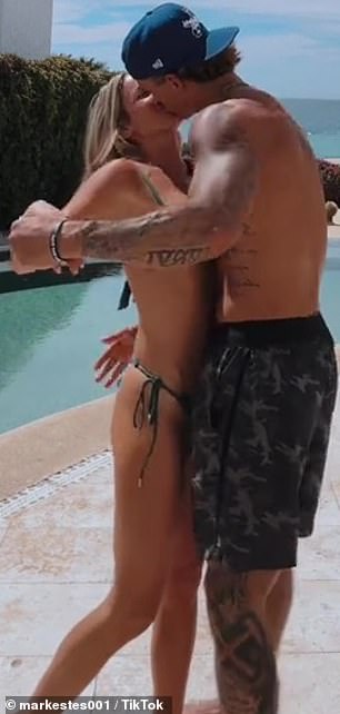 Pictured kissing by the pool during a getaway
