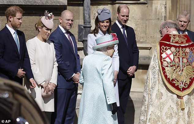 2019 -- Members of the Royal Family, including Prince Harry, Kate and William, watch as Queen Elizabeth II arrives for the Mattins Easter Service at St. George's Chapel on April 21, 2019.
