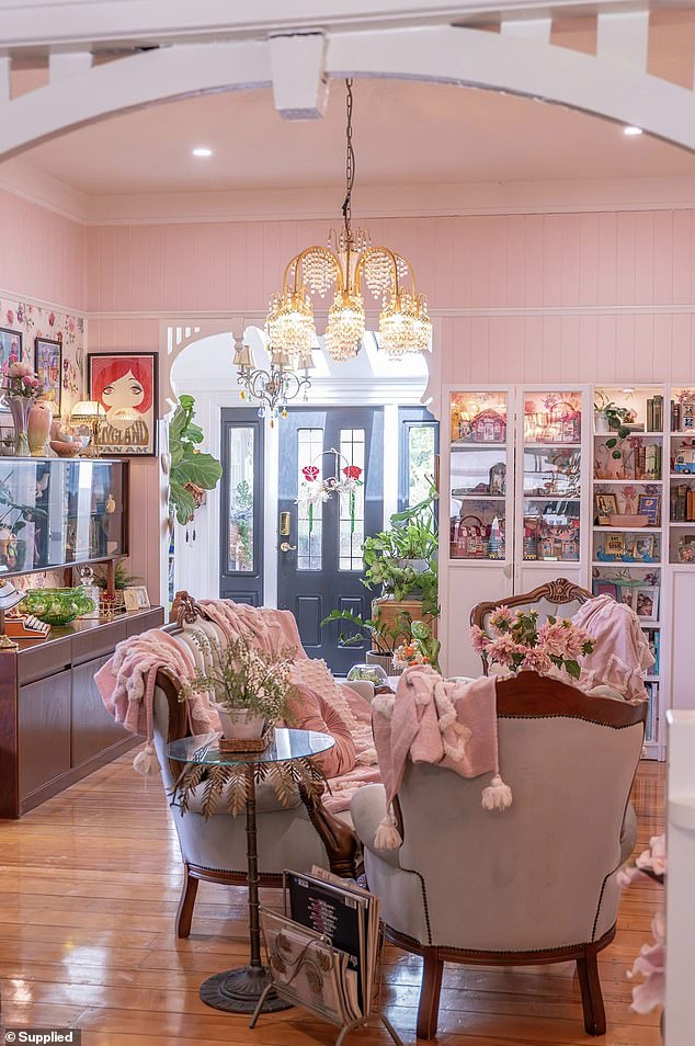 Walking through the front door, your attention is immediately drawn to the baby pink walls, artwork, and floral wallpaper.