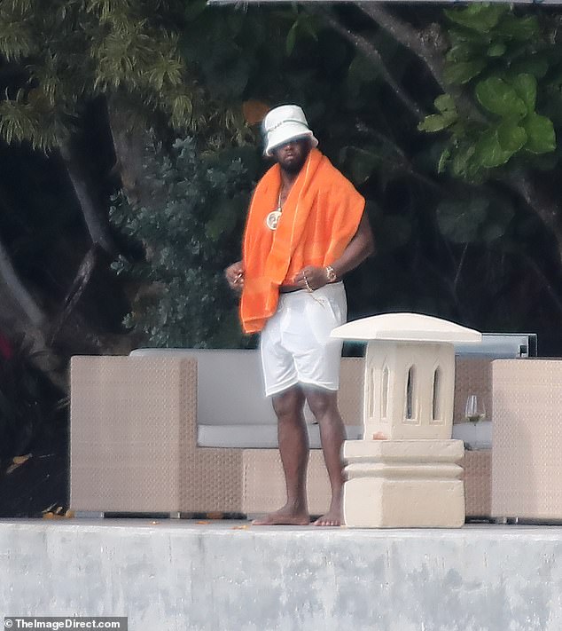 At one point, the embattled rapper reappeared sporting a matching white hat along with a massive gold chain, watch and bracelet and an orange towel slung over his shoulders.