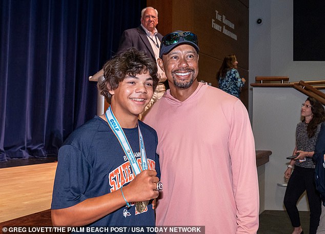 Woods poses with his son Charlie at the state championship celebration on Monday.