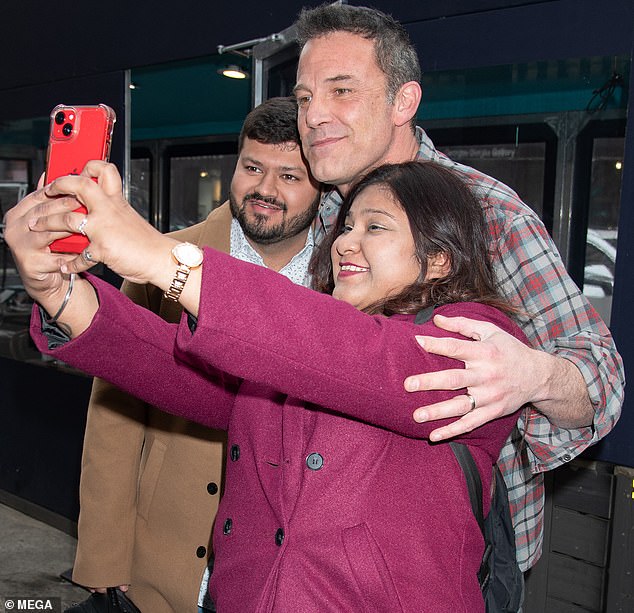 As they walked down the sidewalk, Ben stopped to take photos with a couple of fans who had approached him.