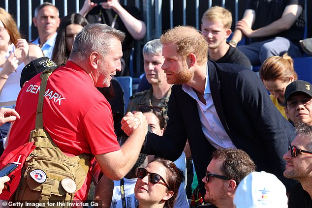 The Duke of Sussex greets a competitor from Team Denmark as he attends athletics on the athletics track during day two of the Invictus Games Düsseldorf 2023 on September 11, 2023.