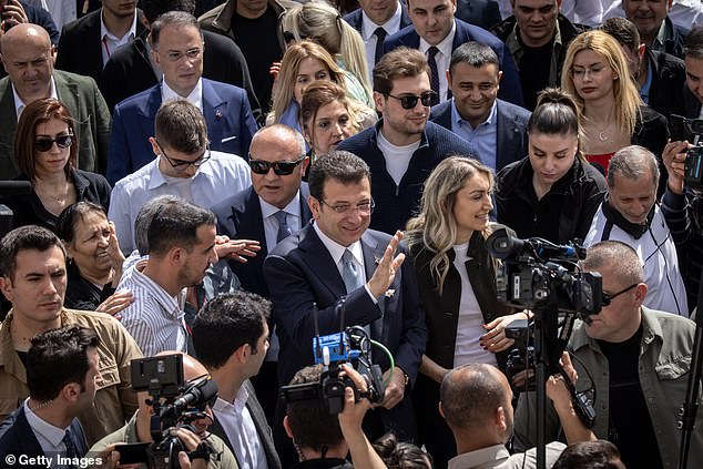 Ekrem Imamoglu, mayor of Istanbul and Republican People's Party candidate for re-election, waves as he arrives to cast his vote.