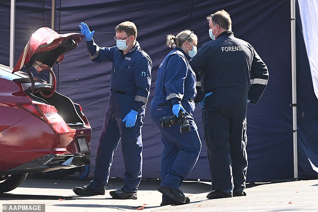 A jogger discovered his body lying next to his car and called the police (photo shows investigators at the scene)