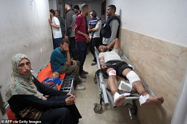 An injured Palestinian lies on a stretcher in a hallway at the Al-Aqsa Martyrs Hospital in Deir al-Balah, central Gaza Strip, following the Israeli bombardment on March 31.