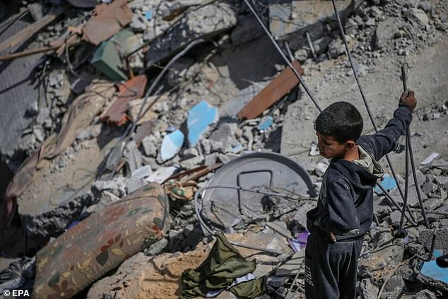 A Palestinian boy inspects his family home destroyed after an Israeli airstrike, in the Al Maghazi refugee camp, in the southern Gaza Strip, on March 31.