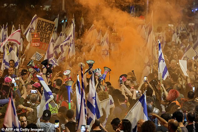 Protesters wave Israeli flags and set off smoke flares as they demand the release of hostages held by Hamas.