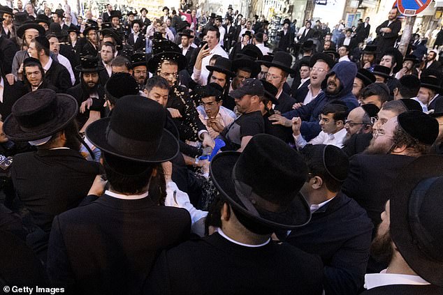 Pictured: Protesters clash with ultra-Orthodox men in the Meha Sha'arim neighborhood of Jerusalem on Sunday.