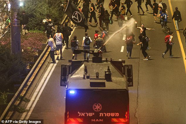 Police break up protesters blocking road with water cannons