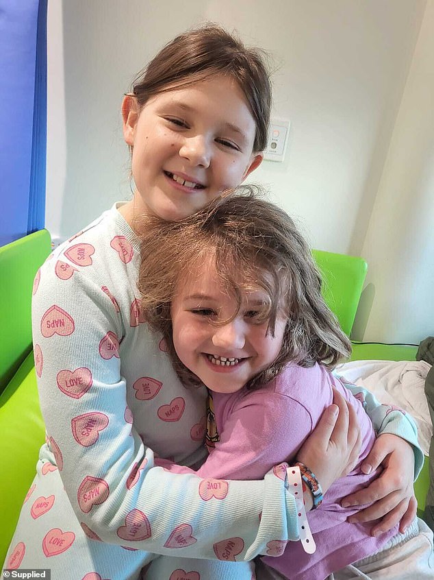 Big sister Evie Whipps is pictured holding and hugging her little sister and best friend Elsie.
