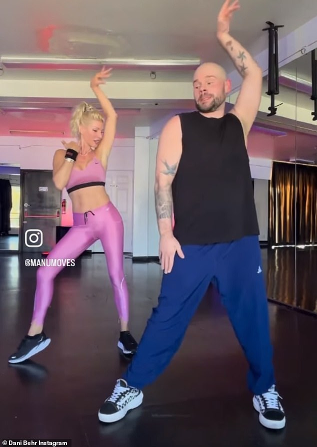 Dani Behr, 53, showed off her washboard abs in a pink sports bra as she shared a grueling video of her morning workout on Thursday (pictured with instructor @manumoves)