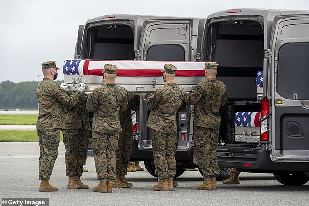 In this photo provided by the U.S. Air Force, a U.S. Marine Corps transport team transfers the remains of Marine Corps Lance Corporal. Kareem M. Nikoui from Norco, California, August 29, 2021 at Dover Air Force Base