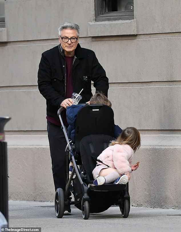 Alec Baldwin looked gloomy as he stepped out with two of his children in New York on Sunday - after his lawyer, Alex Spiro, filed new legal documents to be released in Rust's manslaughter case .
