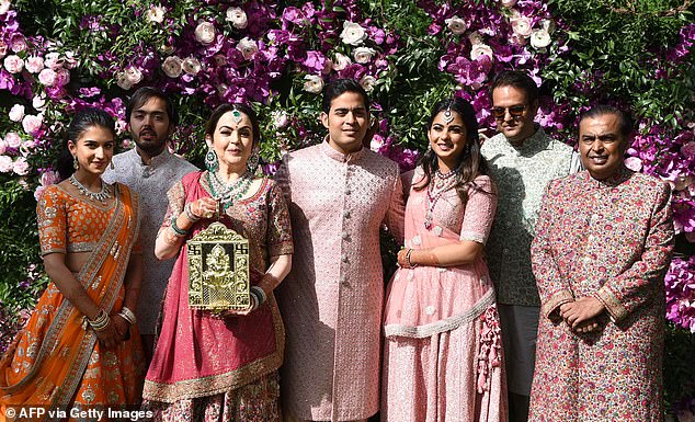 Asia's richest family: The Ambanis pose for a photo at Akash Ambani's (center) wedding anniversary in Mumbai in 2019. Father Mukesh is chairman of Reliance Industries, worth an estimated $112 billion.  He has announced that he will hand over power to his three sons, including Akash, his daughter Isha (third from right) and Anant (second from left).