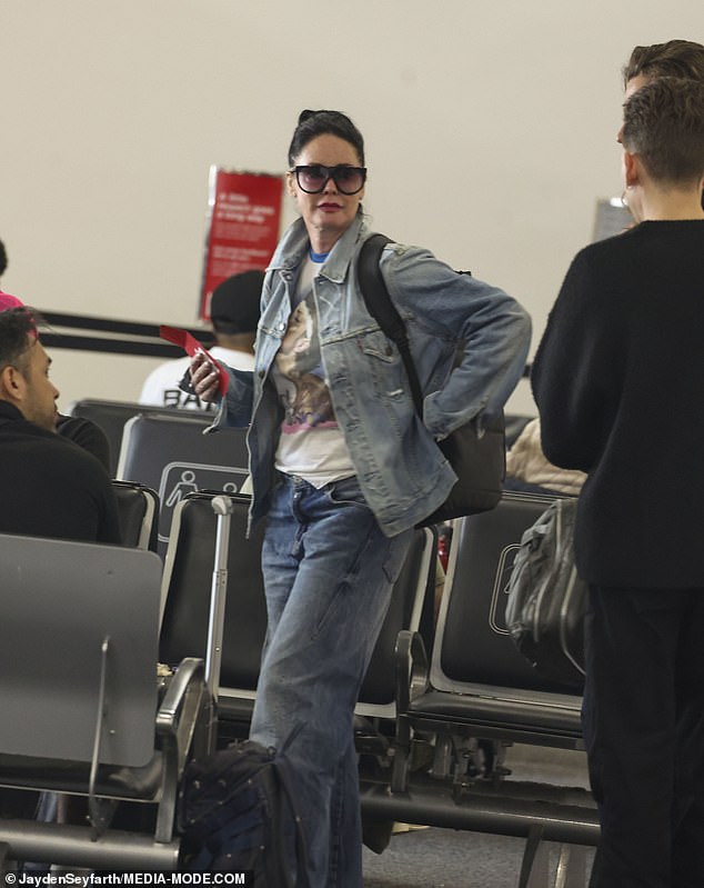 Lene was dressed casually for her flight: she was wearing blue jeans, a matching jacket, and a T-shirt.