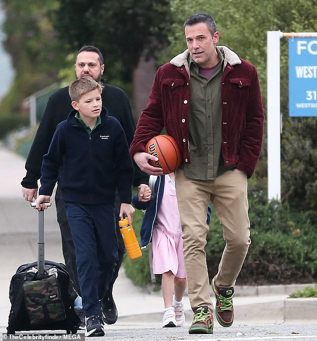 Ben held a basketball while Samuel, 12, pulled his wheeled backpack behind him