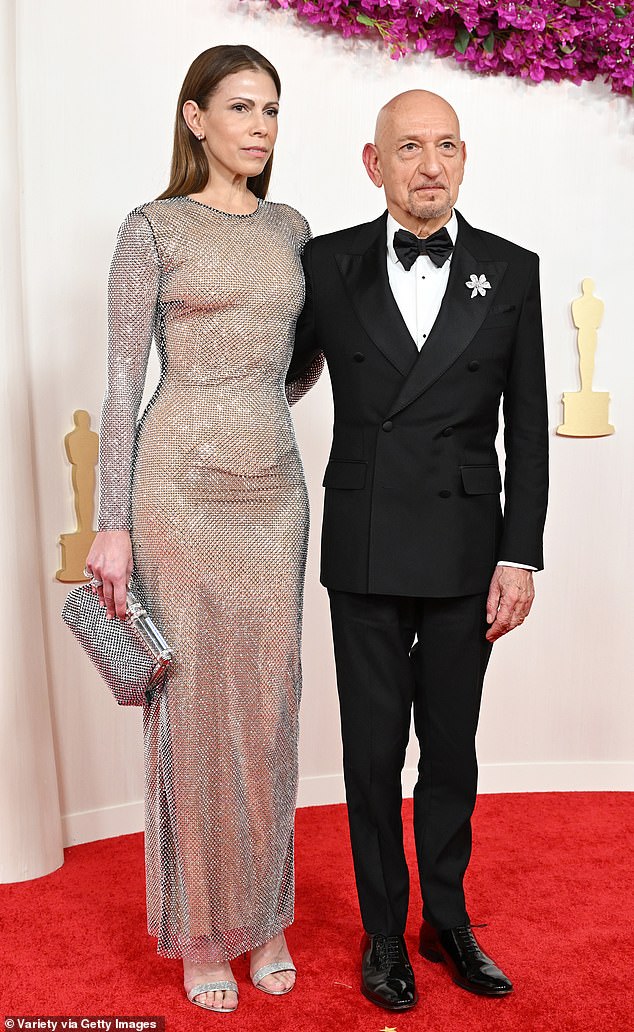 Ben Kingsley's wife made a stunning appearance on the red carpet as she wore a figure-hugging silver dress at the Academy Awards in Los Angeles tonight.