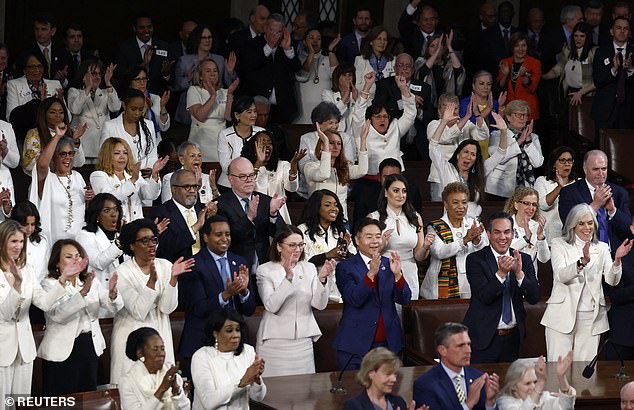 Democratic members of Congress applaud President Joe Biden during State of the Union address; Many Democratic lawmakers wore white to show their support for reproductive rights.