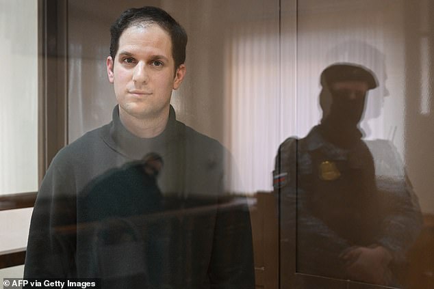 Evan Gershkovich, arrested on espionage charges, looks from inside the defendants' cage before a hearing to consider an appeal over his prolonged pretrial detention, at Moscow City Court on February 20, 2024.
