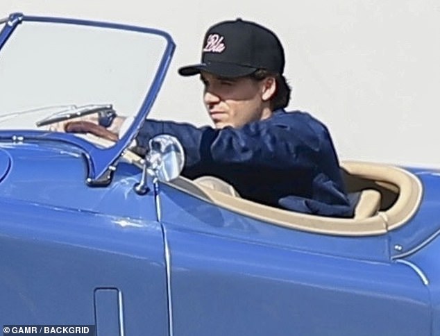 Brooklyn Beckham, 25, soaked up the sun in Beverly Hills on Tuesday in his $500,000 blue vintage electric Jaguar