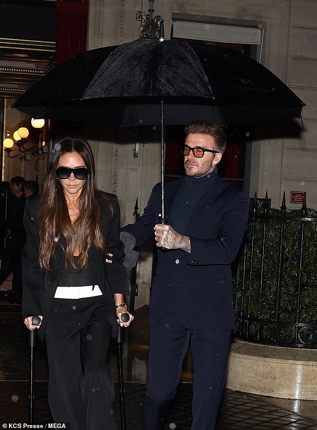 The former footballer helped the former Spice Girl as they headed to a family dinner just 24 hours after her successful fashion week show in the city.