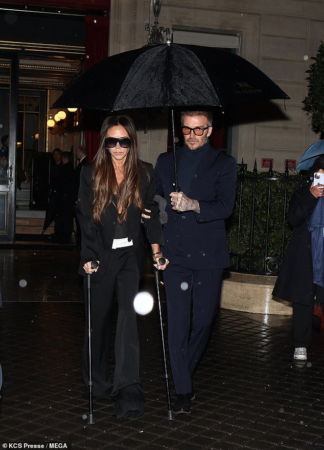 David Beckham, 48, was ever the gentleman as he held an umbrella to protect his wife Victoria, 50, from the rain as they stepped out in Paris on Saturday.