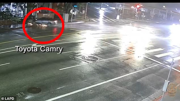 Surveillance footage from across the street reveals the harrowing moment the Toyota Camry crashes into a traffic pole.
