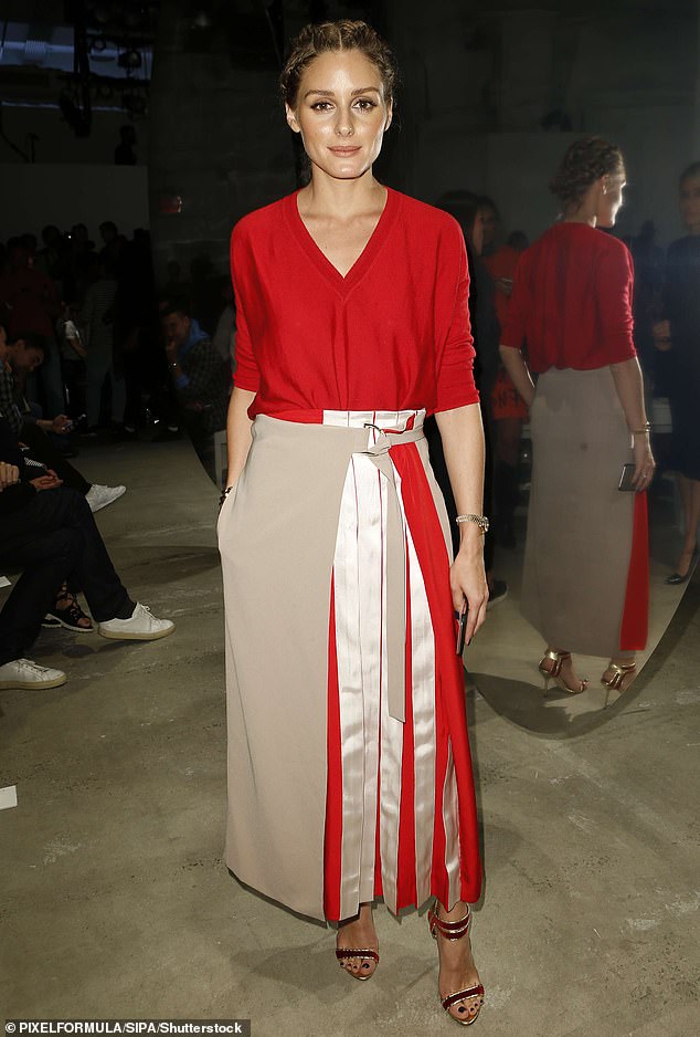 Olivia Palermo combines a fine knitted red sweater with a long cream, red and beige pleated skirt