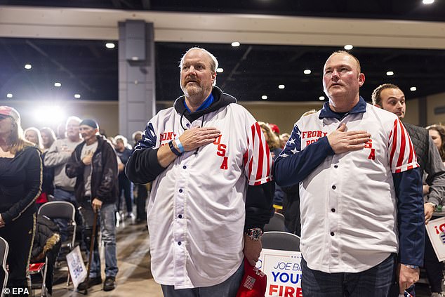 Scott (left) and another Trump supporter cover their hearts during the national anthem.
