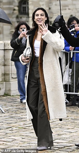 Alexa Chung, 40, looked chic as she greeted fans in a stylish layered coat.