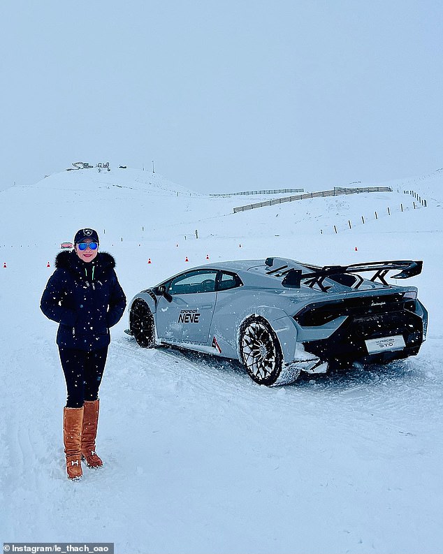 Ms. Thach poses with a car during a snow trip.