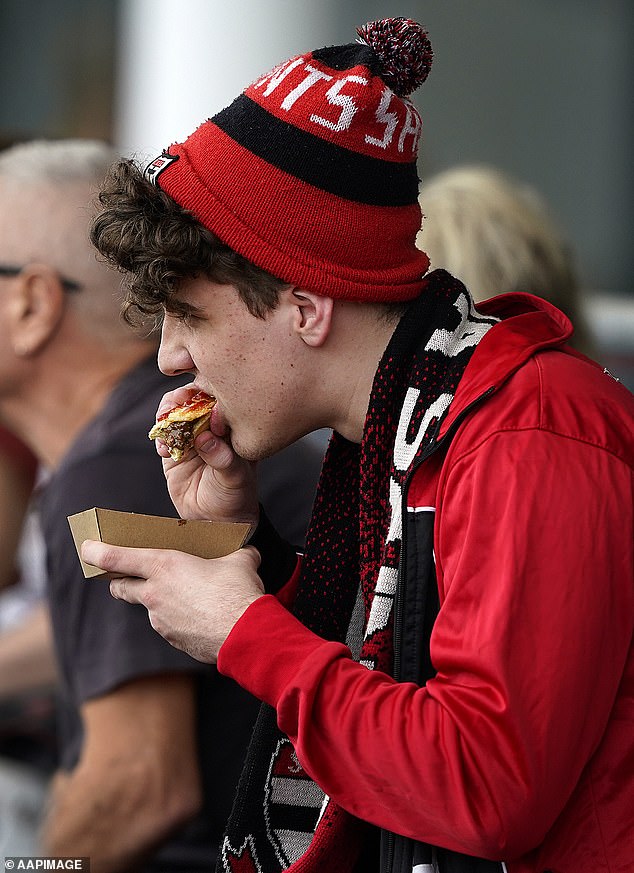 Football fans this season will need to have a lot of money following the sharp rise in prices of many food and drinks at the MCG (pictured, a St Kilda fan enjoying a pie)