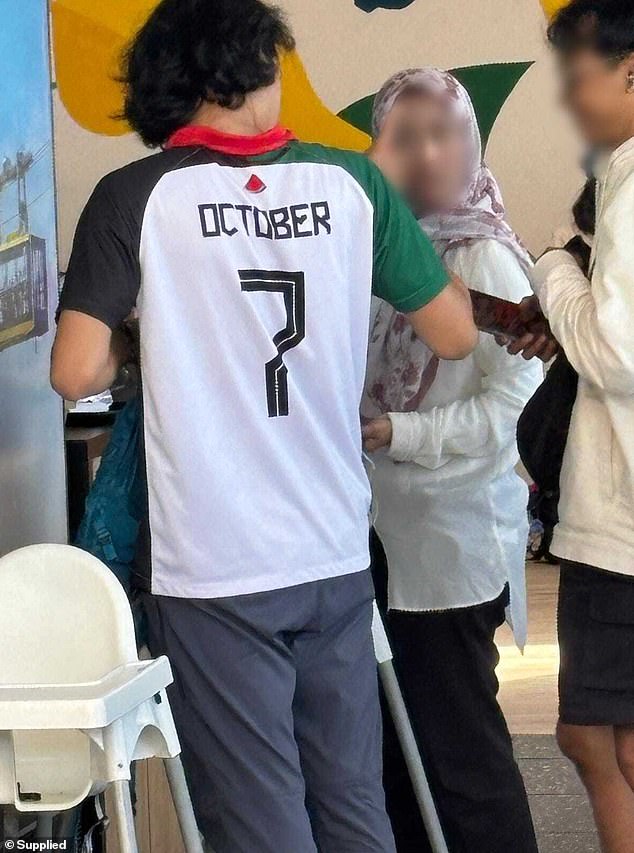 A man wearing a shirt (pictured) recognizing the October 7 attacks carried out by Hamas has angered Australians with police now investigating the incident