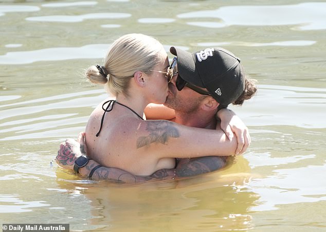 The lovebirds shared a steamy kiss while sunbathing and swimming.