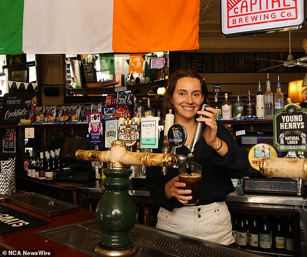 Emma Olrik a bartender at the Australian Hotel in the Rocks serves a Guinness on the Saturday ahead of the official St Patricks Day on Sunday 17th March