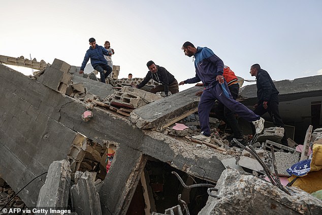Palestinian men search for salvageable items in the rubble of a house destroyed in an overnight Israeli airstrike in Rafah in the southern Gaza Strip on March 3.