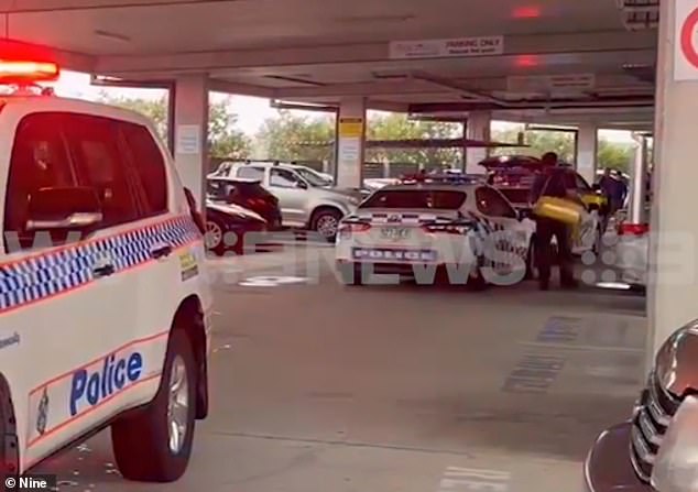 A man has died after being pulled from his car and stabbed in a car park in Hope Island, Gold Coast, on Monday (pictured, police at the scene)