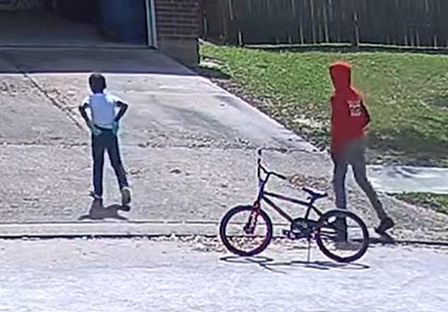Surveillance camera footage from a neighbor's home captured the shorter boy wearing blue gloves and the taller boy wearing a red hoodie and black gloves walking down the woman's driveway.