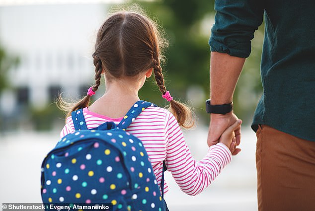Lucy shares the responsibility of running the school with her husband, but admits that she largely carries it out herself.  The photo above shows a father accompanying his daughter to school (archive image)