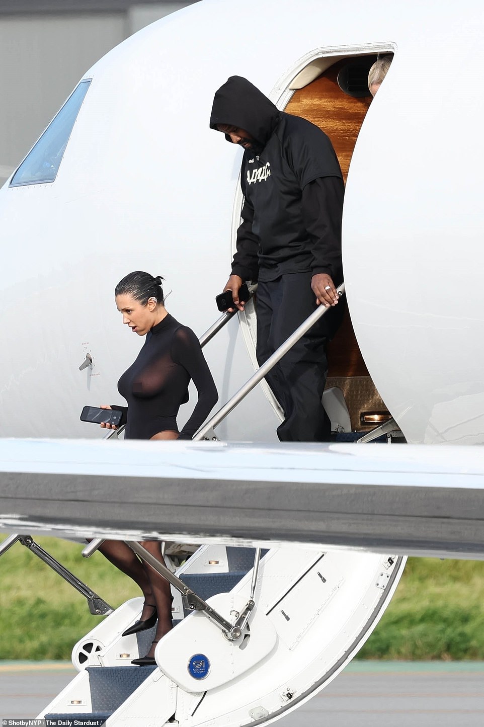 Kanye West's Australian wife Bianca Censori put on another scandalous display as she exited a private jet with her husband in Los Angeles on Wednesday.