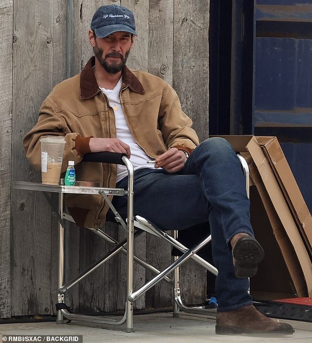 Keanu Reeves while enjoying some downtime on the Malibu set of his upcoming movie Outcome on Saturday afternoon.