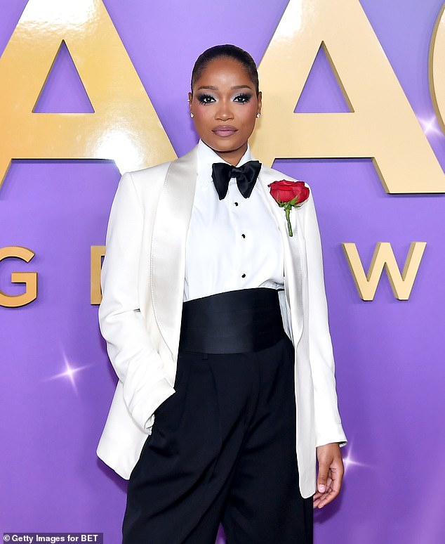 She wore a white button-down with a satin bow and a white blazer as she posed on the red carpet at the Shrine Auditorium and Expo Hall. The Nope star pinned a red rose to the satin lapel of her jacket