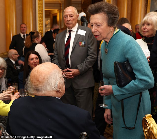 The 73-year-old royal looked focused as she chatted with a veteran while clutching her black leather bag.