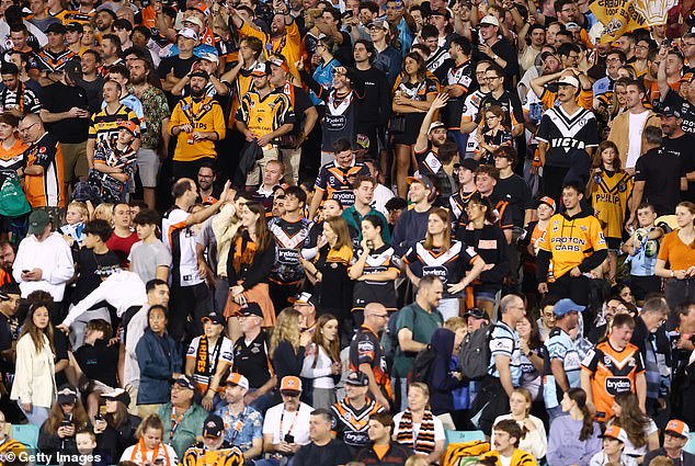 Prominent football commentator Warren Smith used this photo from Saturday night's match to argue that a lack of seats on the hill means children, families and older people are being excluded from Wests Tigers matches in Leichhardt .