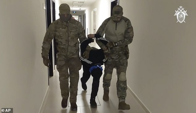 A suspect in Friday's shooting at Crocus City Hall is escorted into the Russian Investigative Committee headquarters in Moscow.